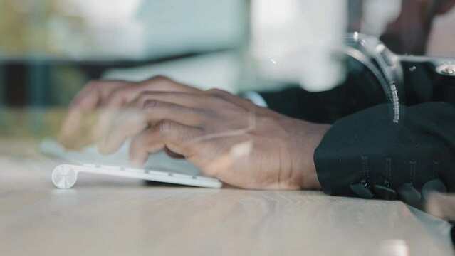 Close up view behind glass hands work with computer keyboard african man businessman technical engineer research information marketing database typing business report e-commerce development in office