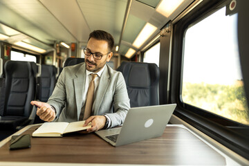 Young business man traveling to work by train, working while traveling, with his laptop and notebook, talking on phone, writing down some goals in notebook.
Business people stock photo
