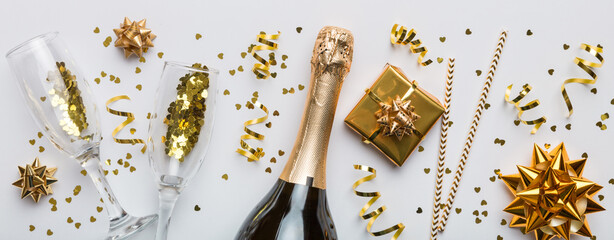 Bottle of champagne with colored glitter, confetti and gift box space for text on colorfull background, top view. Hilarious, christmas and birthday celebration © sosiukin