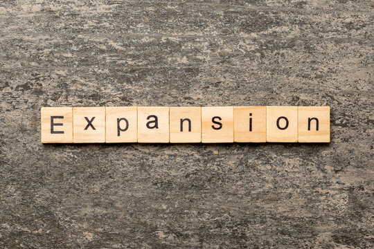 expansion word written on wood block. expansion text on table, concept