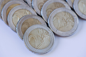 View of several 2 euro coins on white background