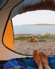 view from a tent on the shore of a lake or sea, camping in nature, wild life in a tent. freedom and relaxation from the hustle and bustle of the city, travel blogger and mental health on vacation