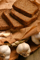 still life of food in a rural style on a dark wood background, rye bread and garlic, concept of fresh vegetables and healthy food