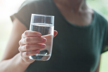 Healthy young woman drinking pure water
