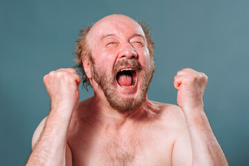 Front view senior man holding hands in fist in front of scream looking up mouth open bald mustache...