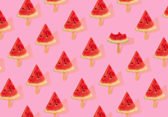 Pattern of watermelon slices that look like ice cream on a stick against pastel pink background. Creative summer food idea.