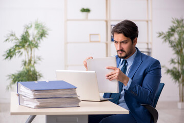 Fototapeta premium Young male employee and too much work in the office