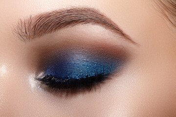 Naklejka premium Closeup Macro of Woman Face with Blue Eyes Make-up. Fashion Celebrate Makeup, Glowy Clean Skin, perfect Shapes of Brows