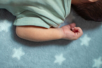 Brazo de un bebé recien nacido caucasico del genero masculino en una sabana con estrellas 