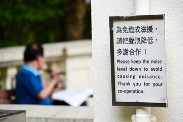 Closeup shot of a sign asking to keep noise levels down in Chinese and English