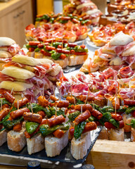 Typical snack of Basque Country and Navarre, pinchos or pinxtos, small piece of bread with different toppings, served in bar, Bilbao, Spain