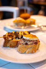 Typical snack of Basque Country and Navarre, pinchos or pinxtos, small piece of bread with different toppings, served in bar, Bilbao, Spain
