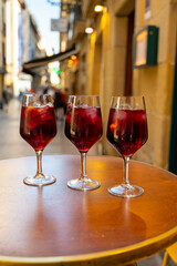 Glasses of cold sangria wine served outdoor in bar with view on old street in San Sebastian, Basque Country, Spain