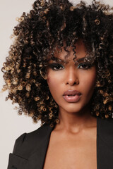 Close-up of African American woman with afro hair posing indoor. Vertical.