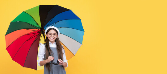 back to school. tween with vivid rain protection. happy school girl in glasses. Child with autumn umbrella, rainy weather, horizontal poster, banner with copy space.