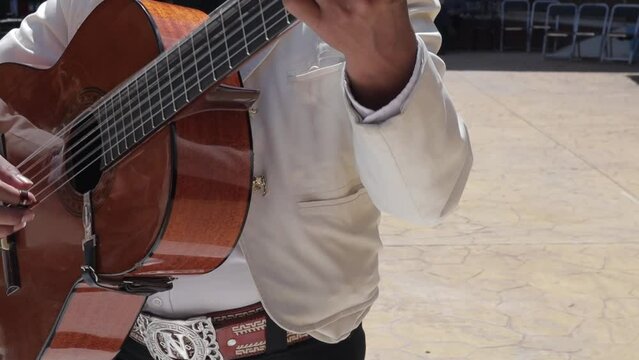 group of mariachi mexican music playing guitar in a public mexican fiesta at a park