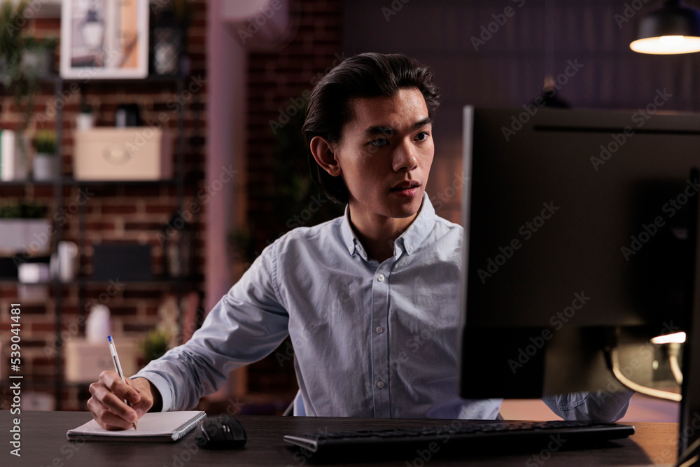 Poster male employee taking notes on files, working on paperwork documents to plan business report remotely