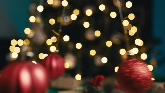 The Christmas red balls pendulum swing against the tree.