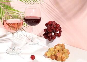 Modern still life with white and red wine, alcoholic margarita cocktail and grapes on pastel background with long hard shadows, minimal concept for bar, cafe, advertising banner, selective focus,