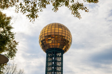 a gorgeous view of the gold and green Sunsphere surrounded by lush green trees with a gorgeous blue sky and powerful clouds in Knoxville Tennessee USA - obrazy, fototapety, plakaty