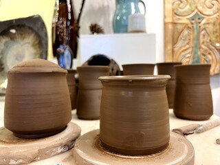 Pottery on the table Beautifully decorated wooden table in a summer open-air cafe. Green branch and fresh flowers table decoration. High quality photo