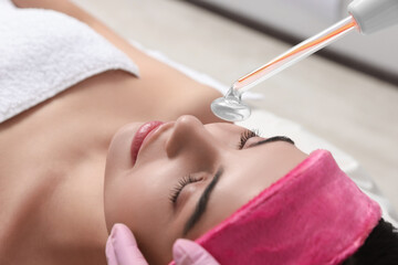 Obraz na płótnie Canvas Young woman undergoing face rejuvenation procedure with darsonval in salon, closeup