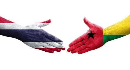 Handshake between Guinea Bissau and Thailand flags painted on hands, isolated transparent image.