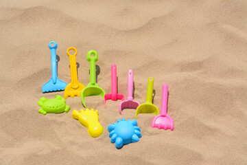 Fototapeta na wymiar Set of colorful beach toys on sand
