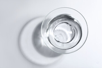 Glass bowl with water on white background, top view