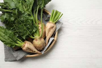 Fototapeta na wymiar Basket with fresh sugar beets on white wooden table, top view. Space for text