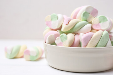 Bowl with colorful marshmallows on white table, closeup