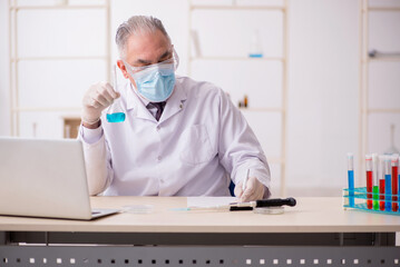 Old male chemist working in the lab during pandemic