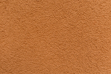 Texture of bright orange plastered and painted wall close-up