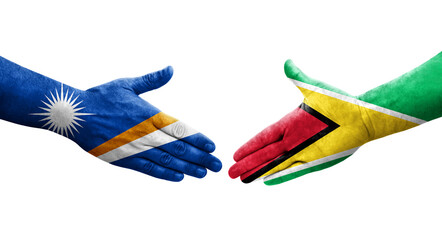 Handshake between Guyana and Marshall Islands flags painted on hands, isolated transparent image.