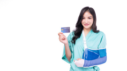 Injured asian woman patient accident broken hand soft splint arm showing mock up credit card standing on white background. Smile young girl hold empty card over isolated.Insurance accident health care
