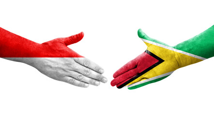 Handshake between Guyana and Indonesia flags painted on hands, isolated transparent image.