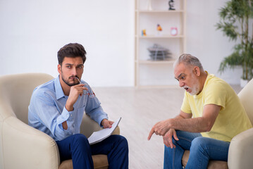 Obraz premium Old man visiting young male psychotherapist