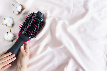 Electric blowout brush hair dryer on a pink background - obrazy, fototapety, plakaty