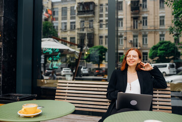 Beautiful woman working on laptop at outdoors cafe