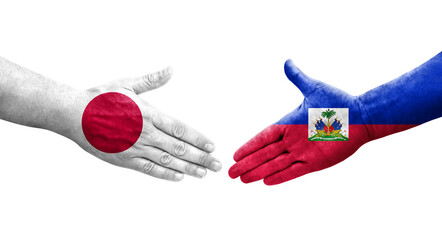 Handshake between Haiti and Japan flags painted on hands, isolated transparent image.