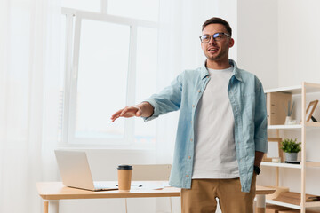 Cheerful happy handsome stylish young businessman in eyewear talk with subordinates staying near office table. Copy space for ad. Remote Job, Technology And Career Profession Concept