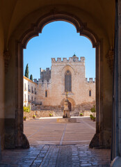 Fototapeta na wymiar View of church main facade with Gothic stained glass window in courtyard of medieval Santes Creus Monastery, Aiguamurcia, Spain..