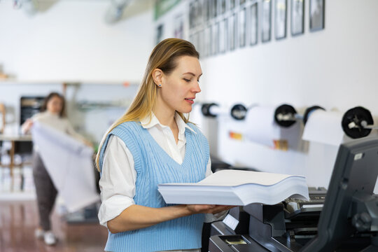 Technician working on plotter and cutter machine in printing centar
