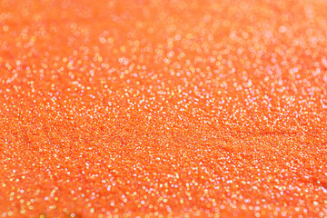 Shiny orange glitter as background, closeup view