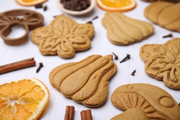 Different tasty cookies, spices and cutter on white table, closeup