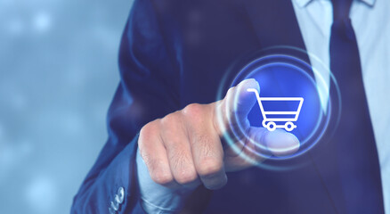 Man pointing at icon of shopping cart on virtual screen, closeup. Online store