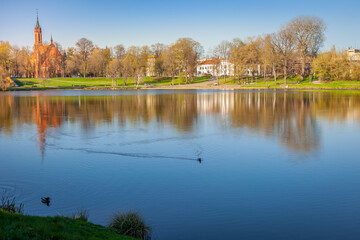 Peaceful city park and church on the lake Druskonis reflection, lithuania