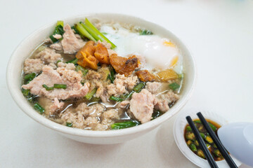 Simple Chinese pork noodle soup with eggs served with lard and chili pepper