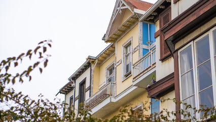 Fachada de antiguas casas de madera, en varios colores, con balcones y ventanas de madera