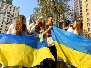 Ukrainians in Vancouver rally in support of Ukraine 4 people of different ages in Ukrainian national clothes with the Ukrainian flag stand and look at each other waiting for end of the war for peace